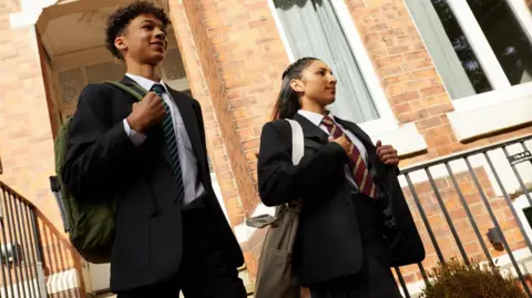 David Luke Two schoolboys in blazers and ties walk out of the building.