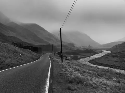 Mohamed Hassan Black and white photo of a country road surrounded by rolling hills in Cwmystwyth, Ceredigion.