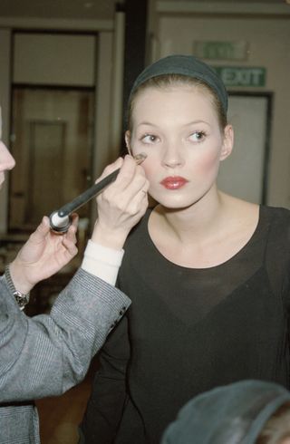 Kate Moss is doing her makeup in the 90s